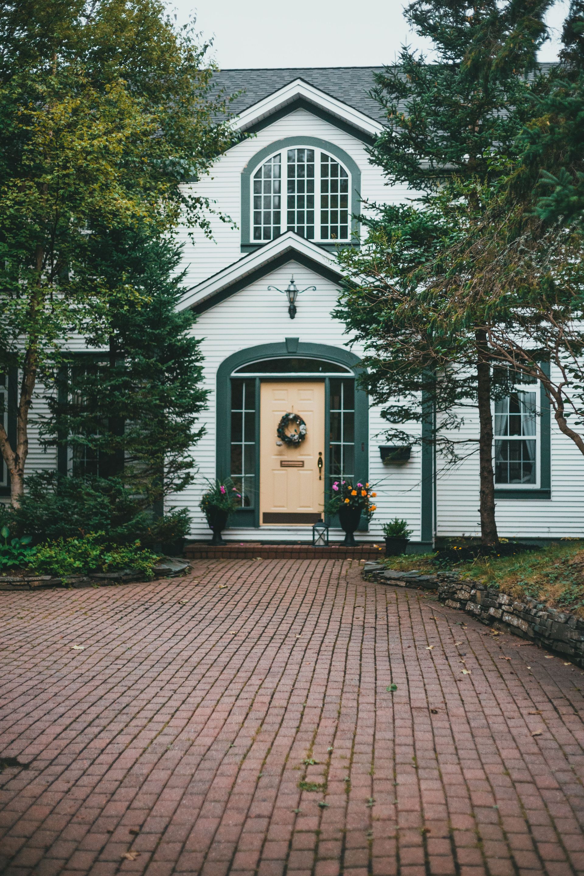 Beautiful colonial-style house front with a welcoming entrance and brick pathway.
